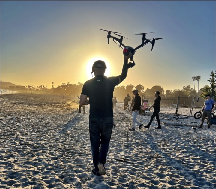 Jorel holding the Inspire drone on a beach at sunset